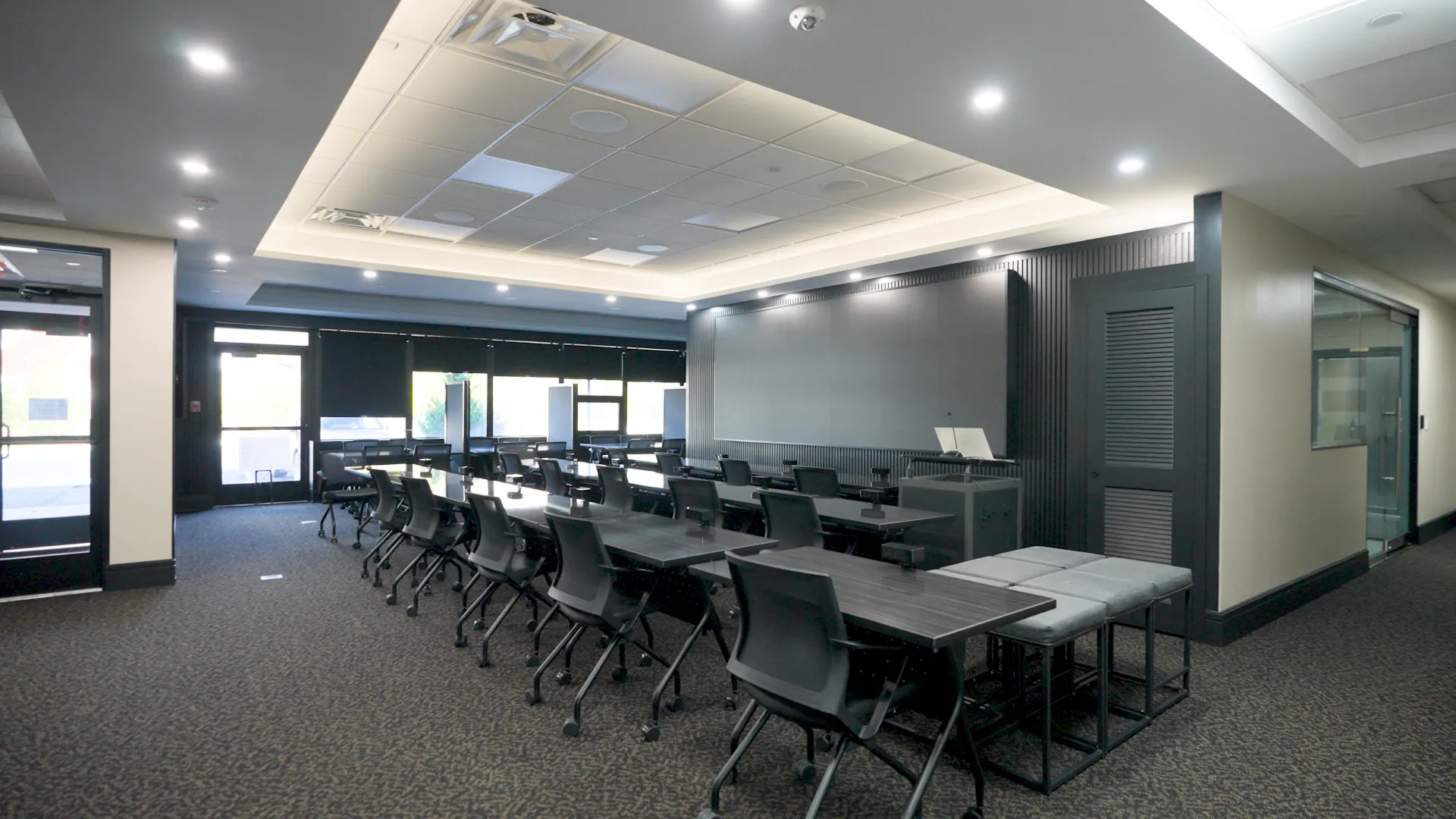 Forum teaching room with rows of desks facing a large presentation screen
